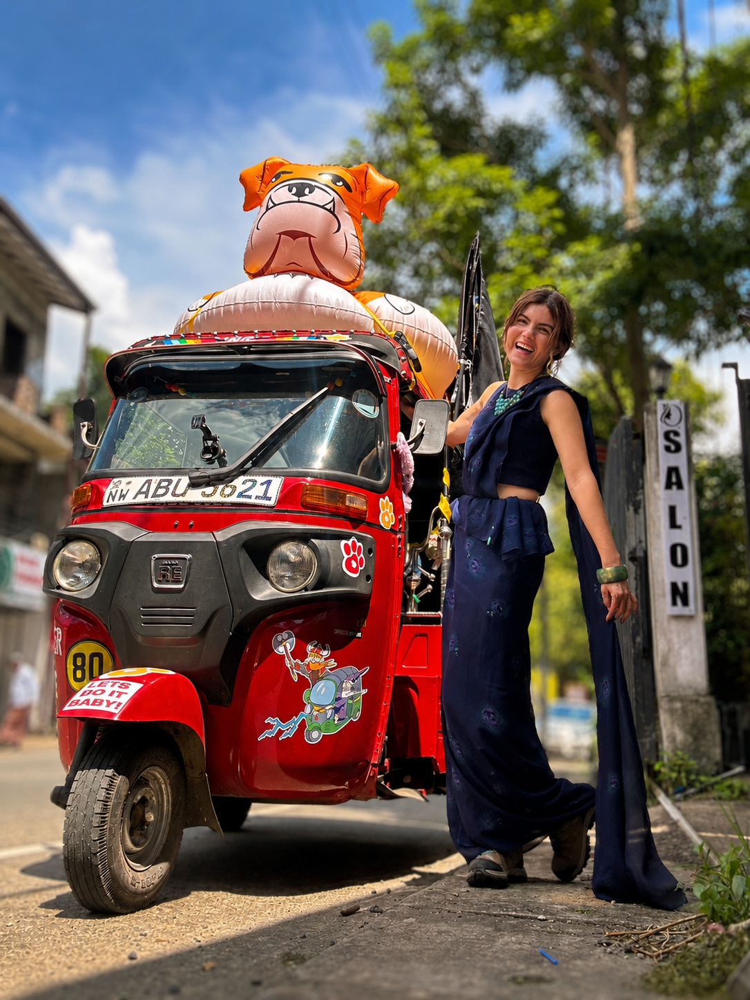 Cassie beside a decorated tuk-tuk during a race abroad